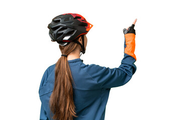 Teenager cyclist girl over isolated chroma key background pointing back with the index finger - obrazy, fototapety, plakaty