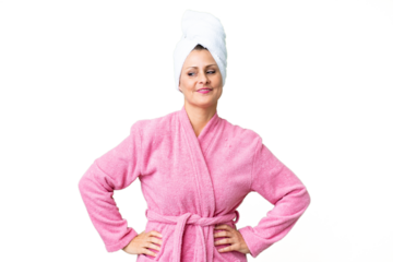 Middle age caucasian woman in a bathrobe over isolated background posing with arms at hip and smiling