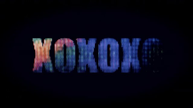 Flashing "XOXOXO" sign with colorful lights against a black background