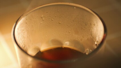 Hot steam comes from freshly brewed black coffee in a glass, alternative beverage making process 4K macro slow motion footage.