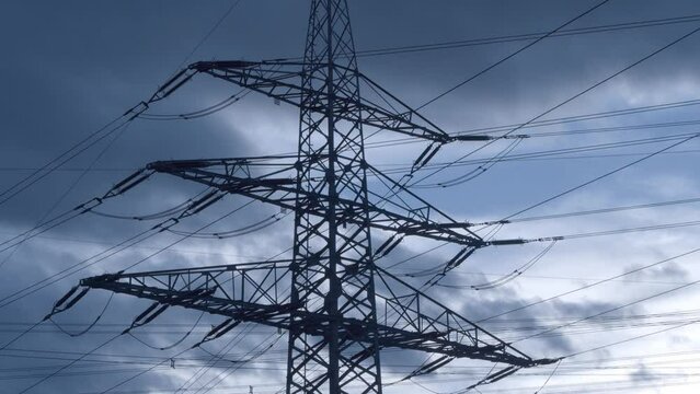 Beautiful fluffy clouds in the blue sky above powerlines during daytime