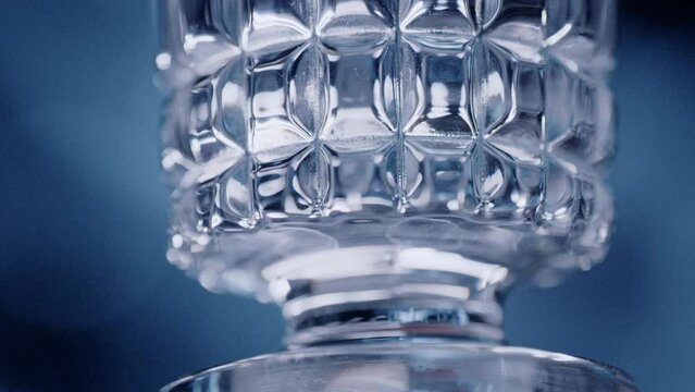 Closeup of a slowly rotating glass for alcohol with beautiful rectangular shapes