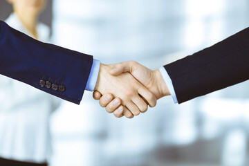 Business people shaking hands at meeting or negotiation, close-up. Group of unknown businessmen and...