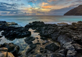Beautiful seascape view with a rocky beach and calm sea water at scenic sunset