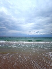 Beautiful waves on the sandy beach, vertical