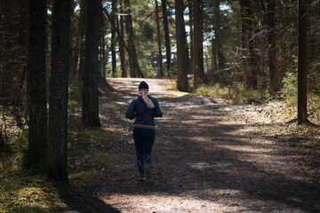 Sports girl runs in the forest.