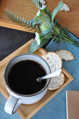 Top view of Hot Coffee Cup with Cracker on Wooden Tray