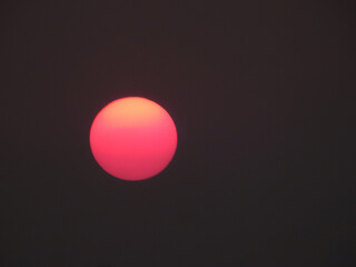 red sun of sunset on black sky background