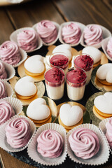 Small cakes with different fillings on the wooden table. Birthday party.