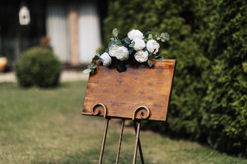 Wedding easel sign in wooden texture with flowers with free space for writing text wedding welcome