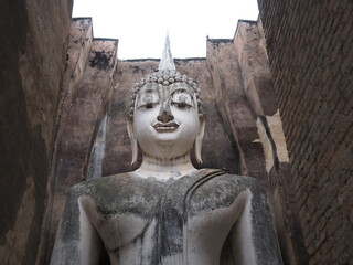 Fototapeta na wymiar Seated Buddha image (Phra Atchana) at Wat Si Chum temple in Sukhothai Historical Park, a UNESCO world heritage site, Thailand
