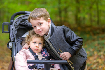 Little girl n the pram and her big brother
