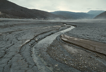 The river grows shallow, the bottom revealed in fresh cracks, the barren valley.