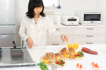 パジャマ姿で朝食を作る日本人の女性