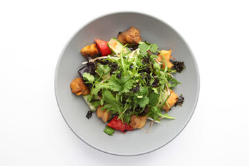 Baked eggplant with arugula, tomatoes and cucumbers. Salad with baked eggplant. Plate on a white background. Isolated object.Flat lay. Top view. Copy space.