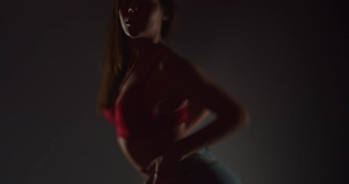 Beautiful girl dancing in bra and jeans, selective focus, silhouette