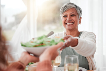Family dinner, senior woman and healthy salad of a happy female with food in a home. Celebration, together and people with unity from eating at table with happiness and a smile in a house giving meal