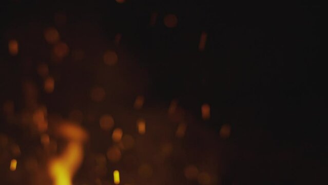 Blurry view of a lot of sparks from large bonfire in the night. Concept of abstract background on theme of fire, light and life