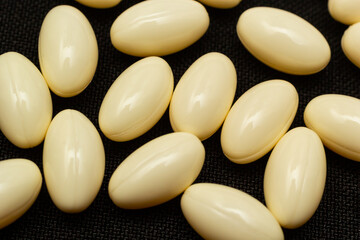 Fototapeta na wymiar Macro Close up of white painkiller tablet on a reflective black background