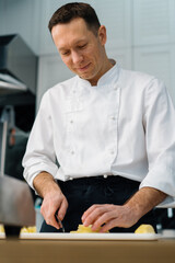 professional chef cutting fruit with knife to prepare oatmeal breakfast healthy food concept