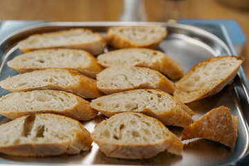 Professional kitchen fresh slices of bread with seasonings lie on a baking sheet close-up of the...