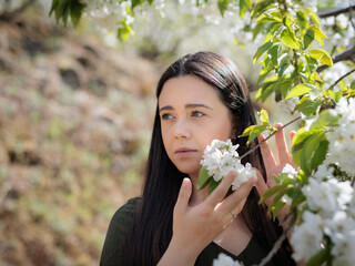 Young woman holds cherry blossoms.