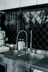 Professional commercial empty clean modern kitchen in restaurant or cafe metal kitchen equipment dishes sink