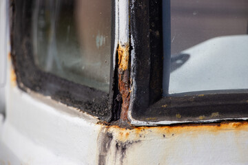 Heavy Rust in the corner of the windshield, on an Oldtimer Camper truck from 1978 before restoration, with multiple bad paint jobs