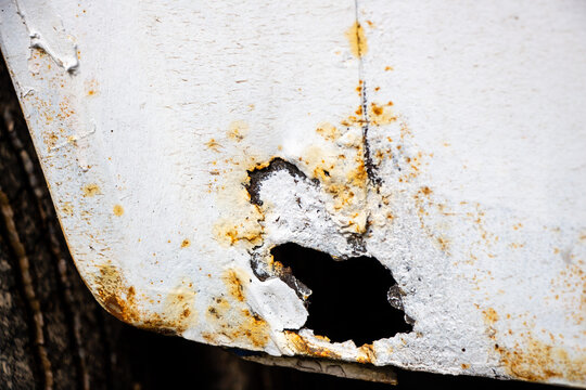 Heavy Rust at the rear wheel arch of an Oldtimer Camper truck from 1978 before restoration, with multiple bad paint jobs