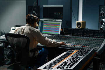 Sound engineer working in music studio with monitors and equalizer on screen mixing and mastering...