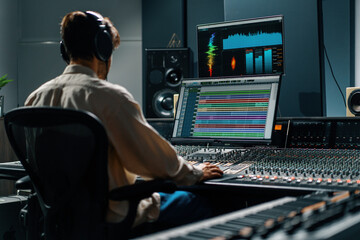 Sound engineer working in music studio with monitors and equalizer on screen mixing and mastering tracks