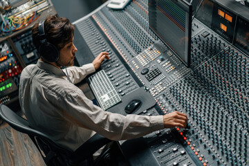 Sound engineer working in music studio with monitors and equalizer on screen mixing and mastering...