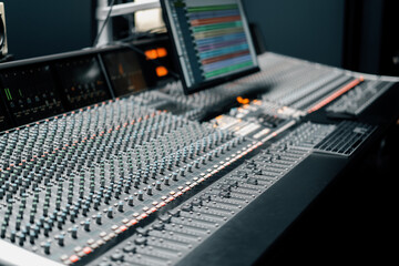 recording studio with a screen with sound wave and volume settings two subwoofers and a mixing...