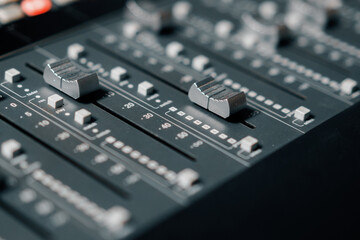 A recording studio control panel mixer with an equalizer faders buttons for broadcasting a recording of a song