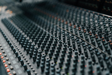 A recording studio control panel mixer with an equalizer faders buttons for broadcasting a...