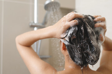 Naklejka premium woman taking shower and washing hair with shampoo