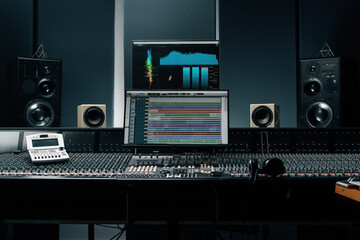 Fototapeta na wymiar recording studio with a screen with sound wave and volume settings two subwoofers and a mixing console