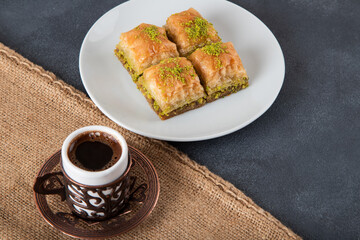 Traditional pistachio baklava with Turkish coffee on black background,top view