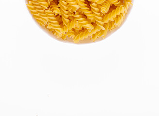 Pasta products in the form of a spiral on a plate, texture, on a white background