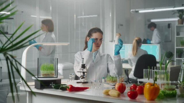 A woman examines a royal oyster mushroom eringi and writes the data on a digital tablet. Research of green sprouts, vegetables, fruits, genetic modification of products grown in the laboratory.
