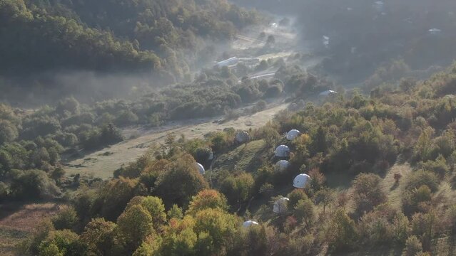 Aerial view of  isolated luxury glamping tents in the forest , Racha, Georgia .