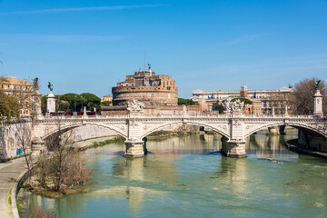 Rom, Italien, Apr. 2023 Der Fluß Tiber mit Ponte Principe Amadeo di Savoia, dahinter die Engelsburg und das Gebäude des Cassationsgerichts vor blauem Himmel