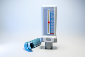 Peak flow meter and a blue inhaler, medical devices for patients with asthma allergy or COPD, light...
