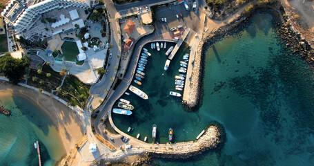 Drone shooting top view of the coast with harbor and small port with stylish yachts, beach and other infrastructure and calm sea with clear blue water in Larnaca Cyprus. © Anton