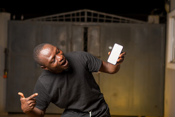 mobile phone mock up. Excited black African man pointing at a blank phone screen, empty space for...