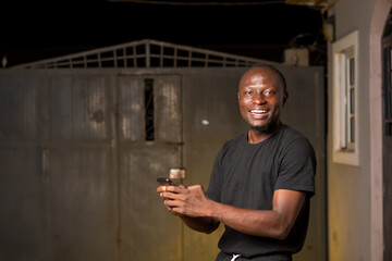 excited young black man standing, using his smartphone.