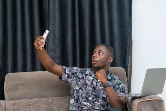 African businessman seated chatting with his client via a conference video call with his mobile phone - Powered by Adobe