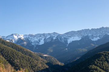 Sunset in some snowy mountains surrounded by pine forests