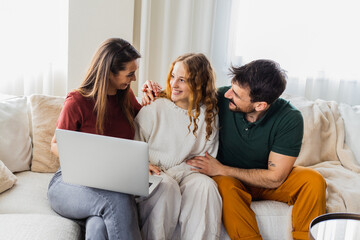 Daughter showing her grades on laptop, parents feeling proud.