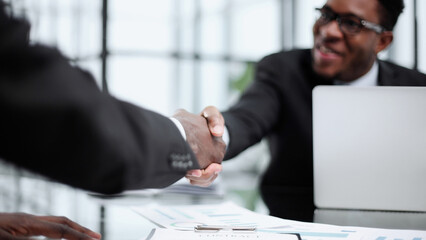 Shot of two young businesmen shaking hands in a modern office